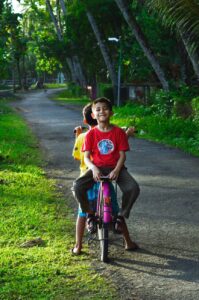 boy riding on back of bicycle